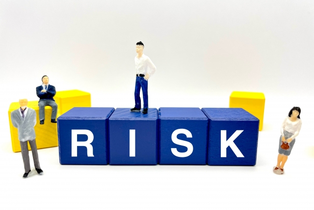 RISKと書かれたブロックとビジネスマンのフィギュア